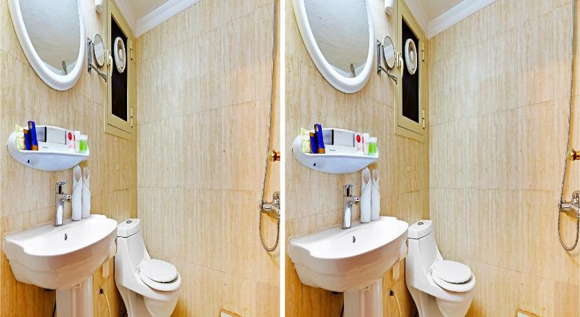 a bathroom with two sinks and two mirrors, Capital O 125 Moon Plaza Hotel in Manama