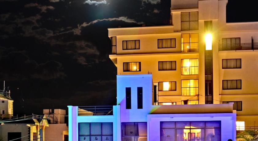 a hotel room with a large white building, Club Denovo in Butwal