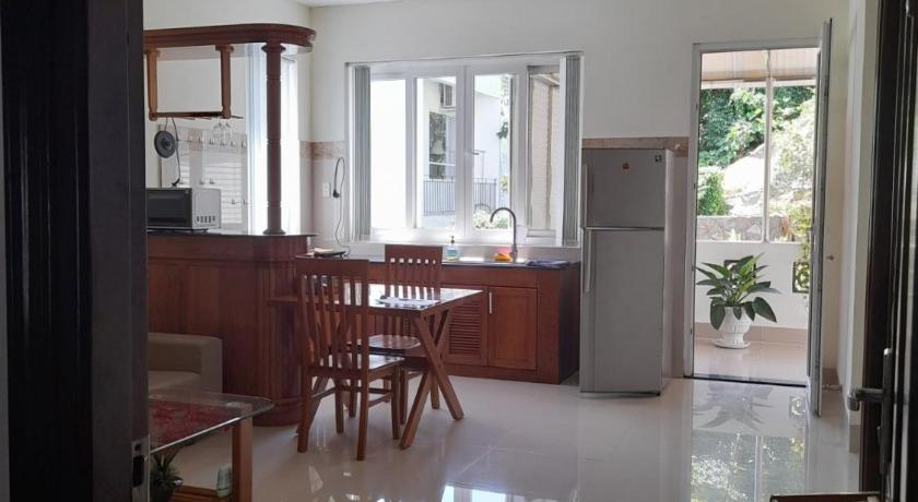 a kitchen with a table, chairs and a refrigerator, Mango Tree Serviced Apartment in Vung Tau