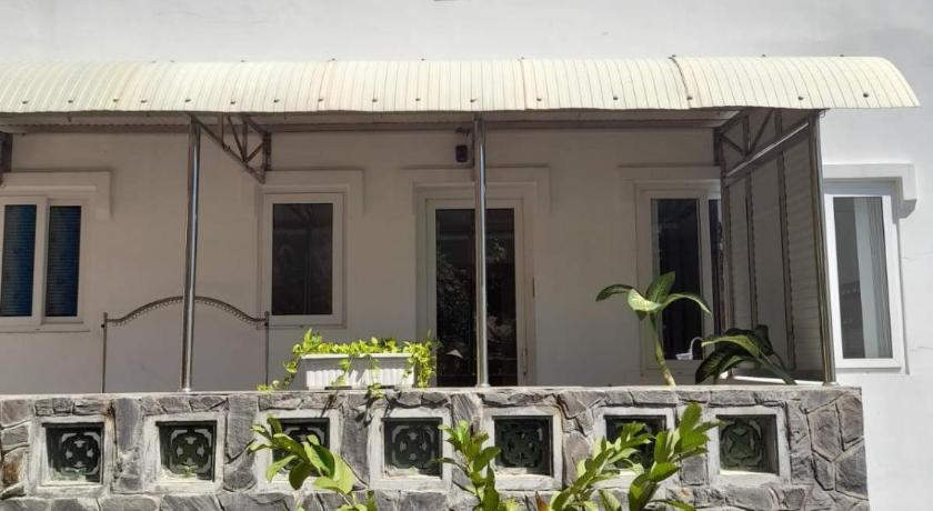 a white building with a window and a bunch of plants, Mango Tree Serviced Apartment in Vung Tau