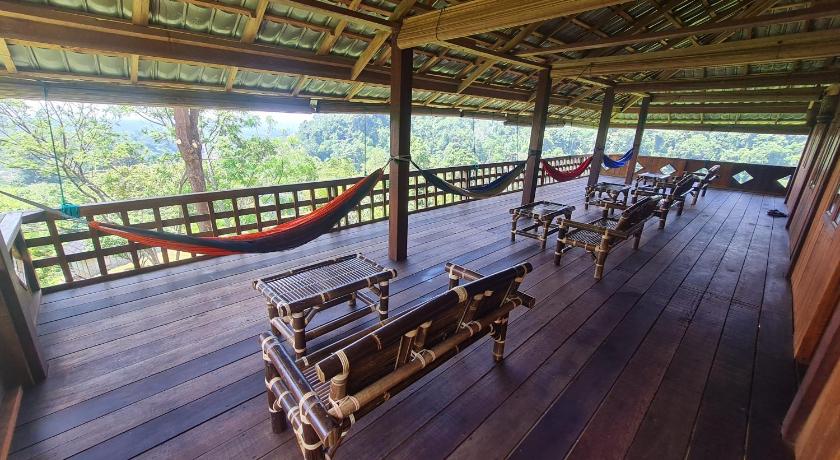 a patio area with wooden benches and wooden tables, Bukit Lawang Hill Resort in Bukit Lawang