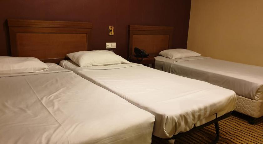 a hotel room with two beds and two nightstands, Oxford Hotel in Singapore