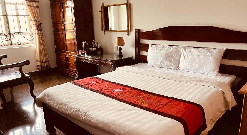 a hotel room with a bed and two lamps, Maison Vu Tri Vien in Hue