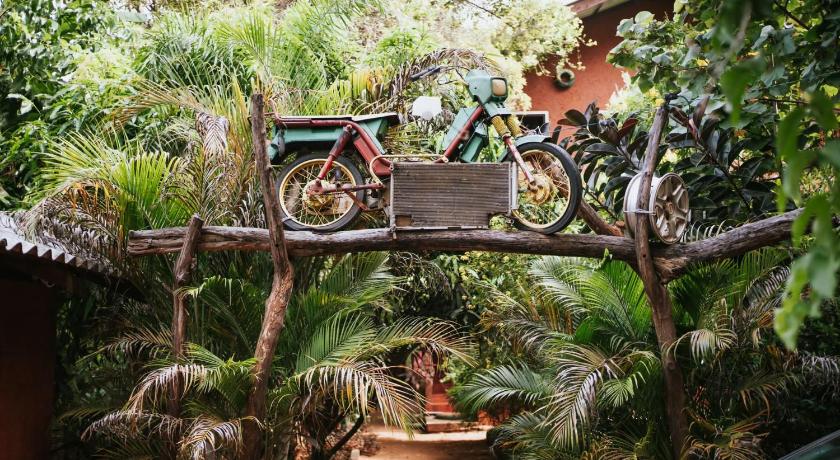 a bike parked next to a tree in a garden, Hotel Hideaway Garage in Sigiriya