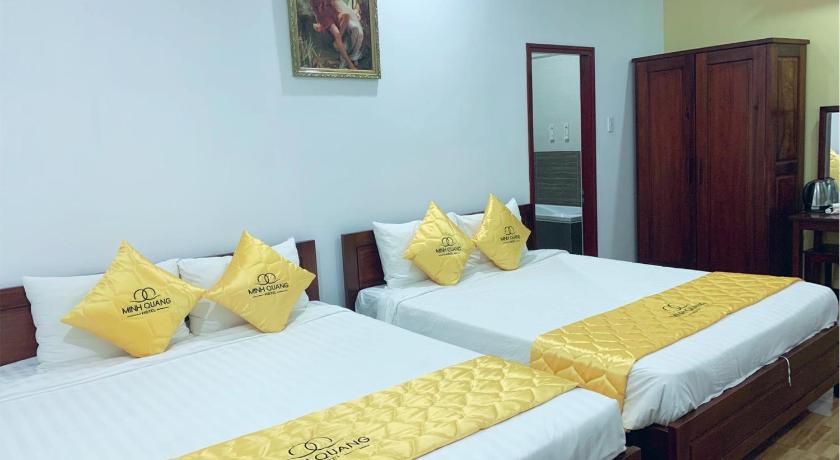 a hotel room with two beds and two nightstands, Khach san Minh Quang in Phan Rang – Tháp Chàm (Ninh Thuận)