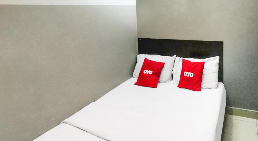 a bed with a white comforter and pillows, OYO 89950 365 Nice Stay in Miri