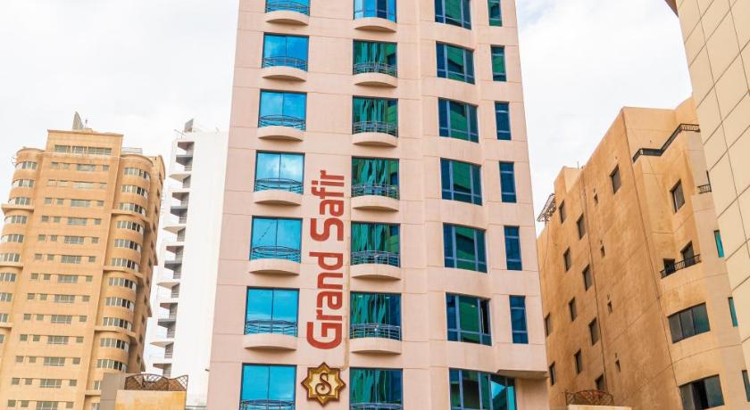 a tall building with a clock on the side of it, Grand Safir Hotel in Manama