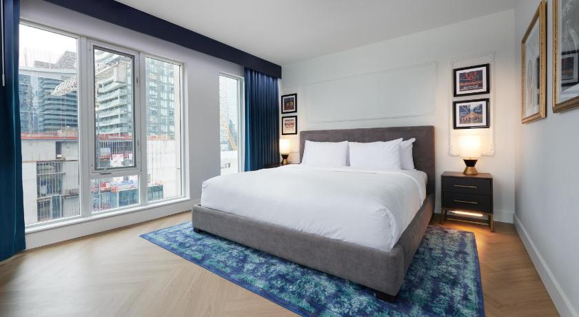 a bedroom with a large bed and a large window, Pantages Hotel Toronto Centre in Toronto (ON)