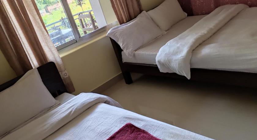 a bedroom with two beds and a window, Hotel Green Hill View in Pokhara