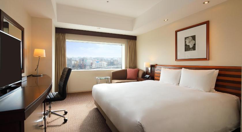 a hotel room with a large bed and a large window, ANA Crowne Plaza Okayama in Okayama