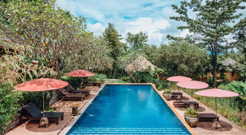 a pool with a pool table, chairs and umbrellas, Villa Khao Phaengma in Khao Yai