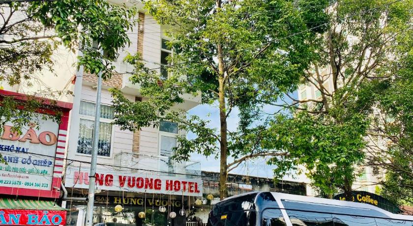 a double decker bus driving down a street, Hung Vuong Hotel in Buon Ma Thuot