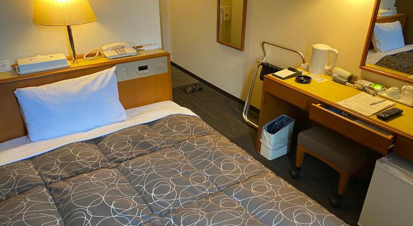 a hotel room with a bed and a desk, Az Inn Fukui in Fukui