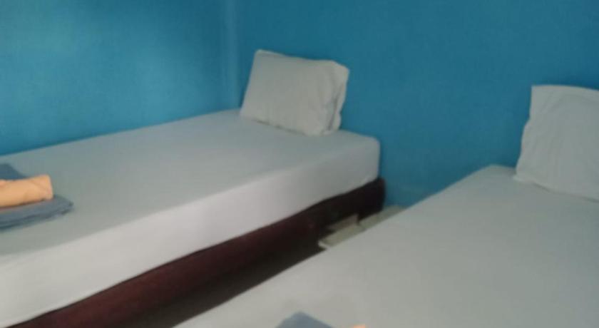 two beds in a room with a blue wall, Charung Beach in Ko Pangan