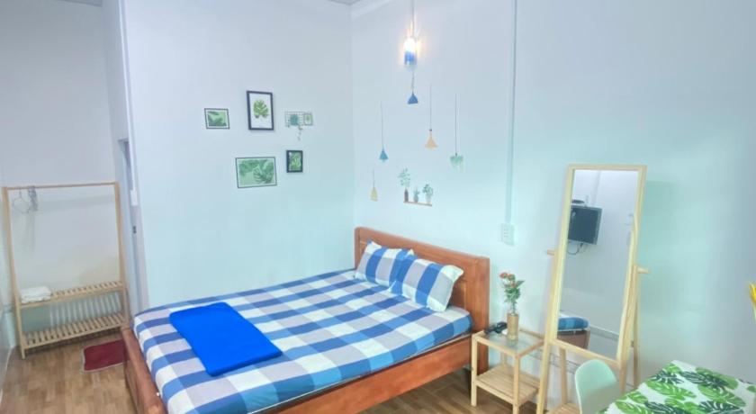 a bedroom with a bed, a desk, and a painting on the wall, Nha nghi Gia An in Lai Son