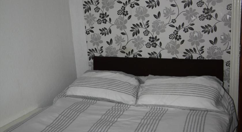 a bed with a white comforter and pillows, MyRoomz Jesmond International Hotel in Blackpool