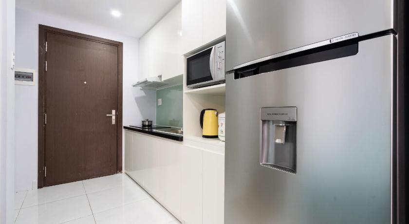 a kitchen with a refrigerator, microwave, and sink, ZO APARTMENT RIVER GATE - Free Gym and Pool in Ho Chi Minh City