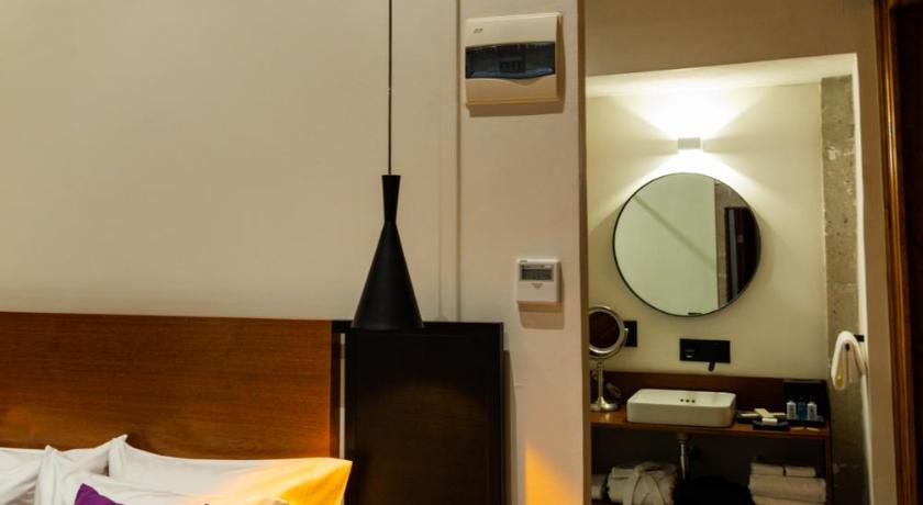 a hotel room with a bed and a lamp, Casa de la Luz Hotel Boutique in Mexico City