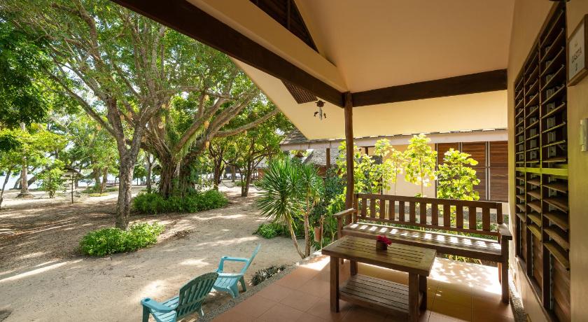 a patio area with a bench and a tree, Virgin Beach Resort in Batangas