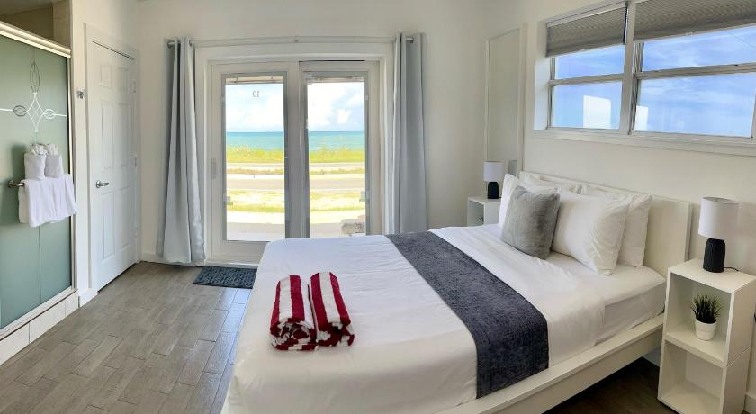 a bed room with a white bedspread and pillows, A1A Ocean Club in Flagler Beach (FL)