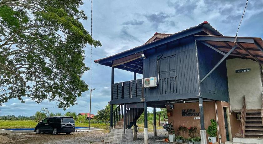 a house with a wooden roof and a building, Kejora Homestay in Kangar