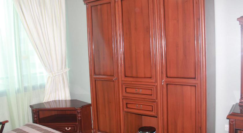 a room with a wooden floor and a wooden dresser, Rainbow Hotel Apartments in Abu Dhabi