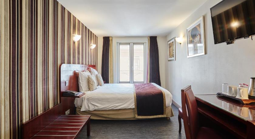a hotel room with a bed, chair, and nightstand, Hotel Opera d'Antin in Paris