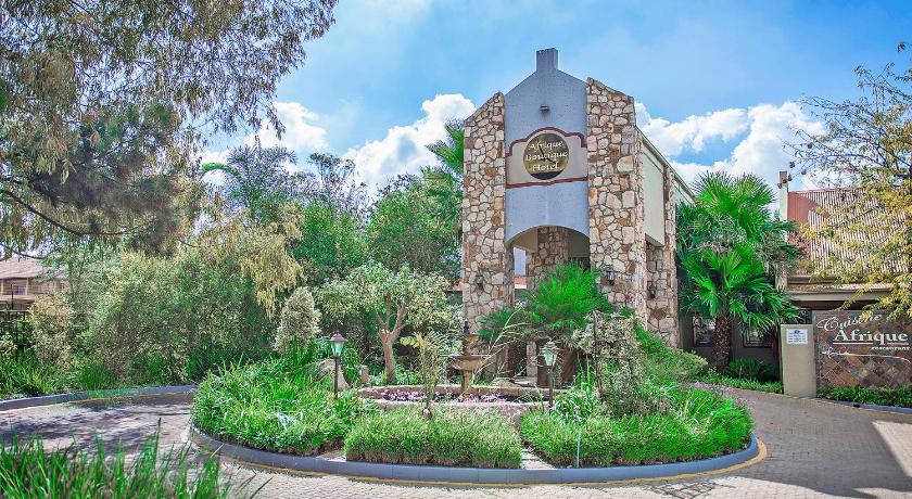 a large stone building with a clock on it, Afrique Boutique Hotel O R Tambo Boksburg in Johannesburg