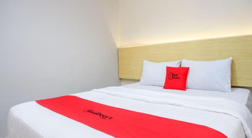 a hotel room with a white bed and white comforter, RedDoorz near Stasiun Batang in Bandung