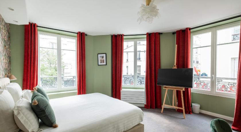 a living room with a bed and a tv, Hotel Des Batignolles in Paris