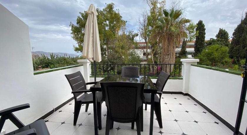 a dining room table with chairs and a patio, Nerjavacaciones - El Califa in Nerja