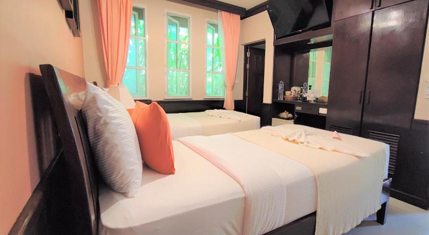a hotel room with two beds and a television, Samed Villa Resort (SHA Extra Plus) in Ko Samet