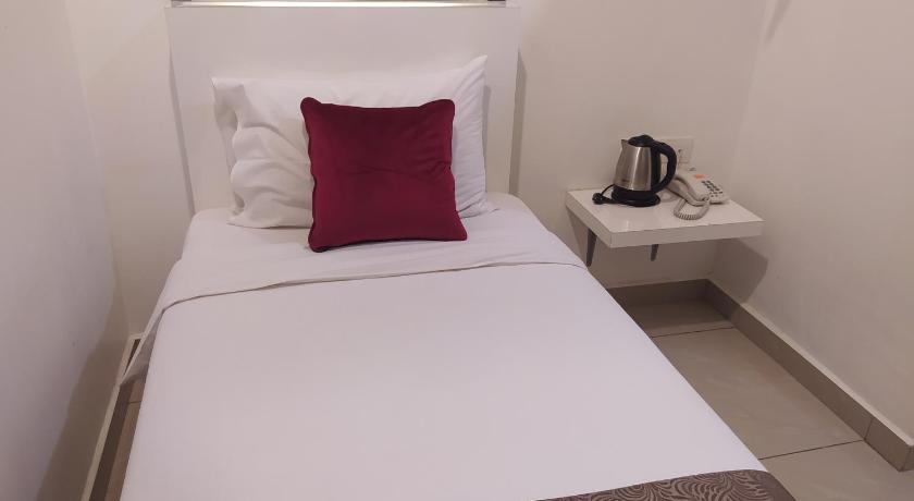 a white bed with a white comforter and pillows, Crescendo Boutique Hotel in Johor Bahru