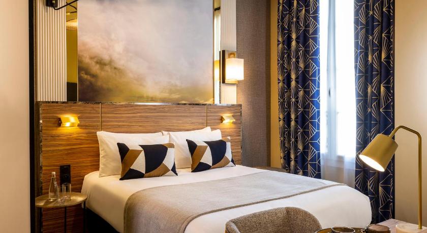 a hotel room with a large bed and two lamps, Le Rocroy Hotel Paris Gare du Nord in Paris
