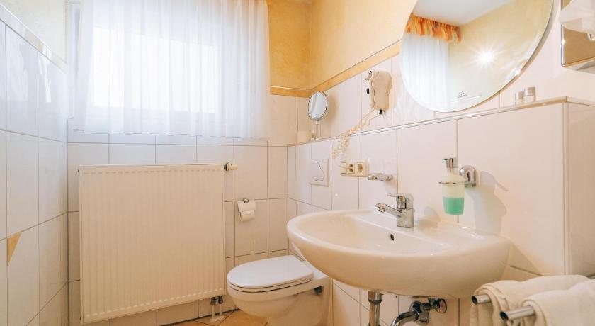 a white toilet sitting next to a sink in a bathroom, Hotel Abenstal in Au In Der Hallertau