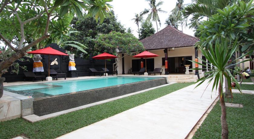 a patio area with a pool, chairs, and umbrellas, Hotel Melamun in Bali