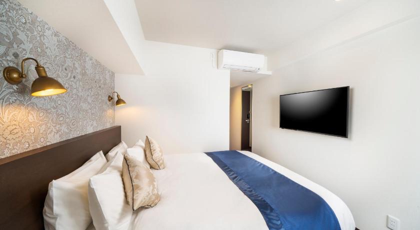 a hotel room with a bed and a television, Best Western Hotel Fino Shin-Yokohama in Yokohama