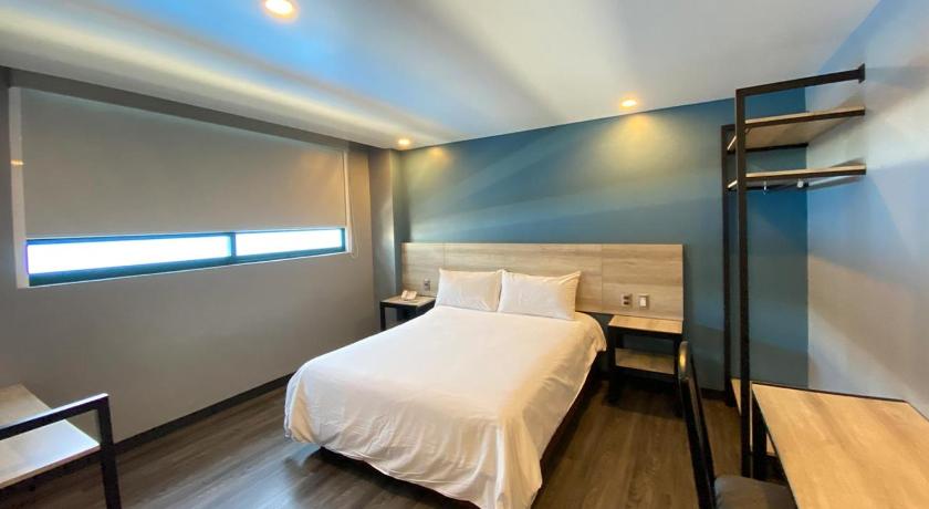 a hotel room with a bed and a desk, Hotel Estrella de Oriente in Mexico City