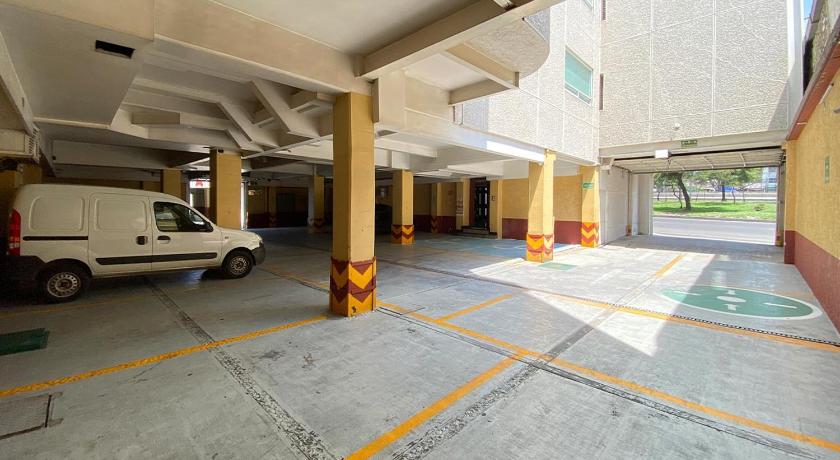 an empty parking lot with a large building behind it, Hotel Estrella de Oriente in Mexico City