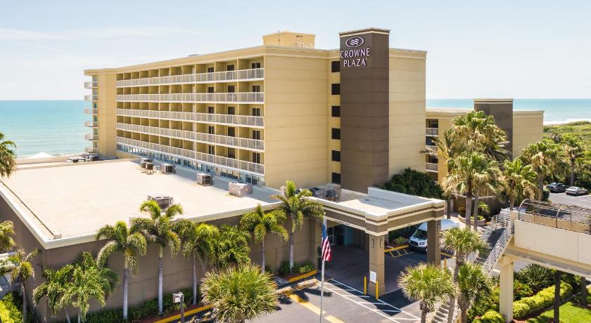 a large building with palm trees in front of it, Crowne Plaza Melbourne-Oceanfront in Indialantic (FL)