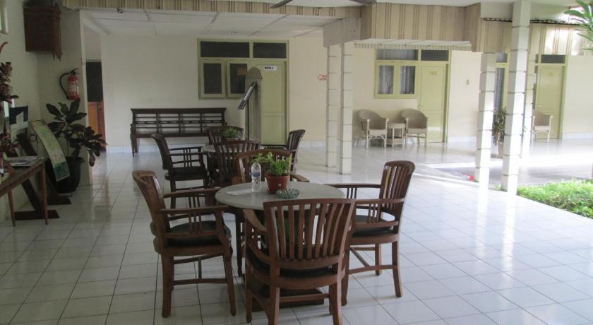 a dining room with a table and chairs, Hotel Grand Rosela Yogyakarta in Yogyakarta