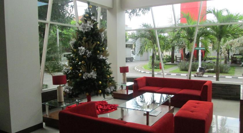 a red christmas tree sitting in a living room, The Victoria Hotel Yogyakarta in Yogyakarta
