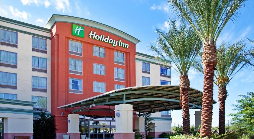 a large building with a palm tree in front of it, Holiday Inn Phoenix Airport in Phoenix (AZ)