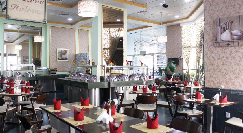 a restaurant filled with tables and chairs, Al Diar Dana Hotel in Abu Dhabi