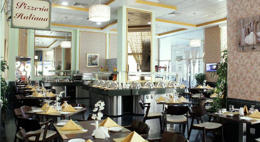 a restaurant kitchen with tables and chairs, Al Diar Dana Hotel in Abu Dhabi