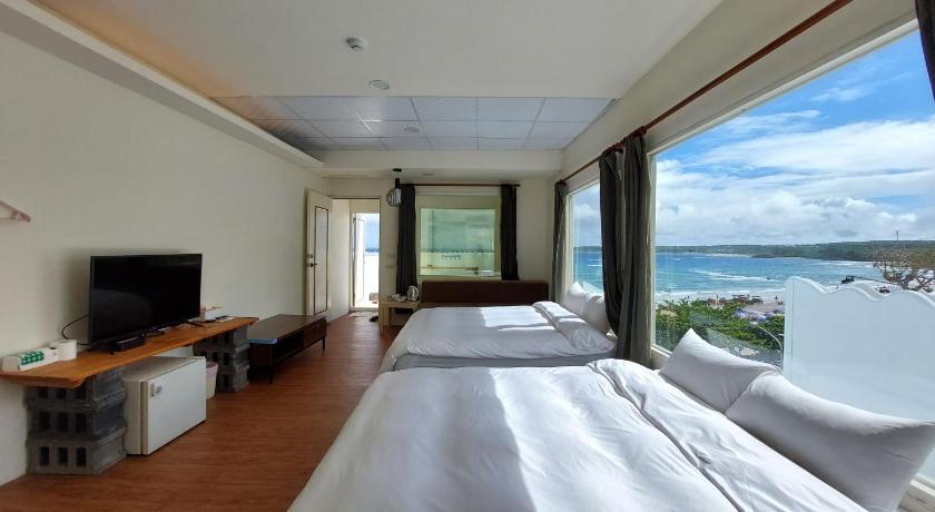 a hotel room with two beds and a balcony, Hearty Homestay in Kenting