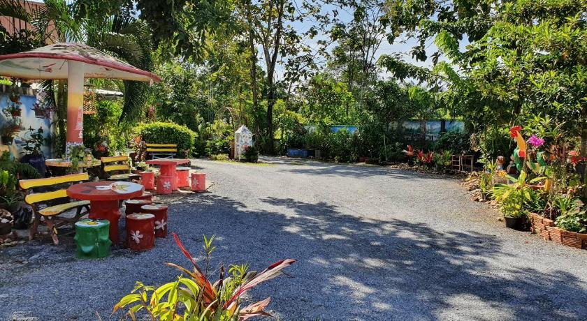 a garden area with a bench and a fire hydrant, สิชล บ้านอุ๊ รีสอร์ท in Nakhon Si Thammarat
