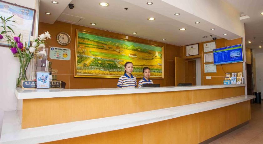 a woman standing in front of a large counter, 7 Days Inn Wuhan Shifu Branch in Wuhan