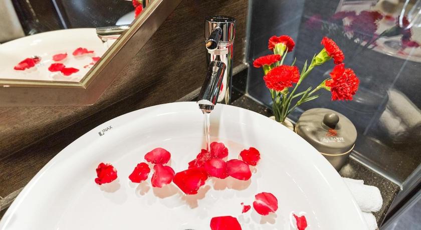a white sink with flowers in it, La Santé Hotel & Spa in Hanoi
