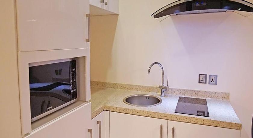a kitchen with a sink and a microwave, Novotel Suites Riyadh Olaya in Riyadh